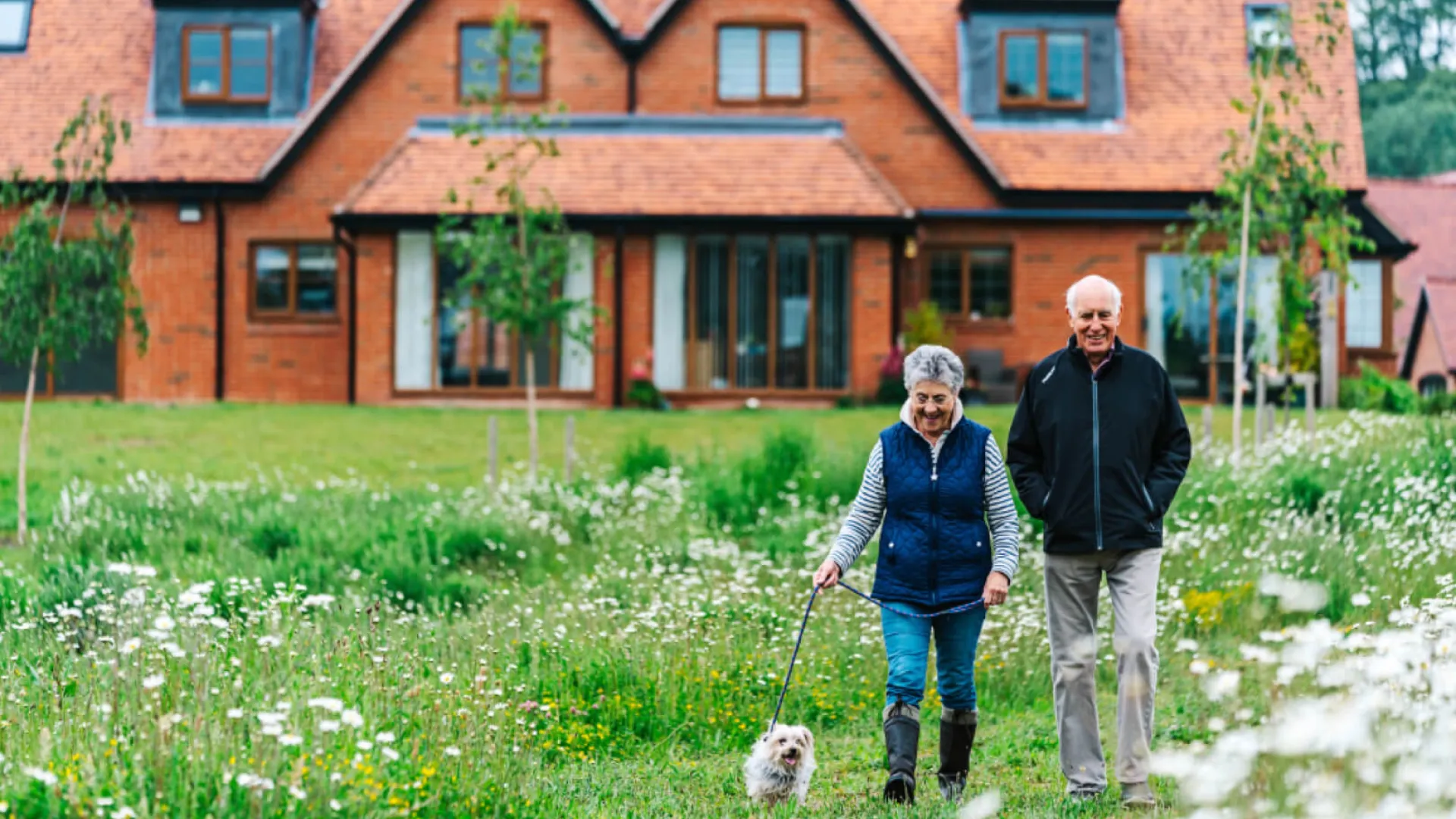 A couple walking a dog at Great Alne Park