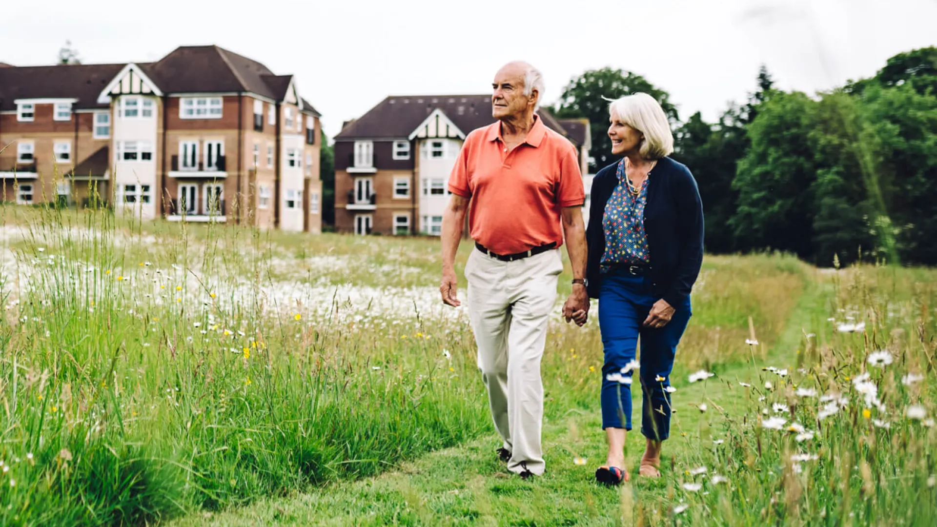 Older couple walking through meadow