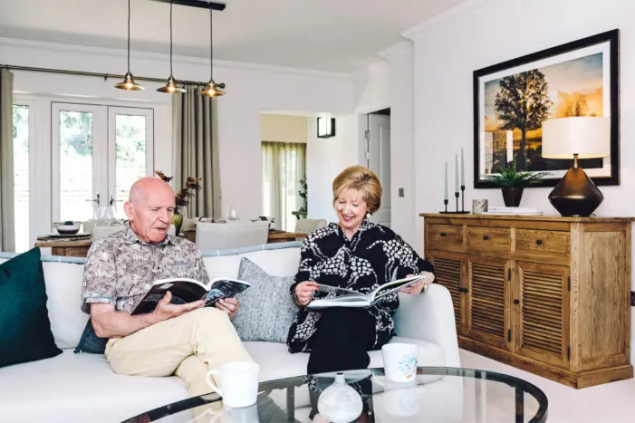 Two people sitting on a sofa reading books