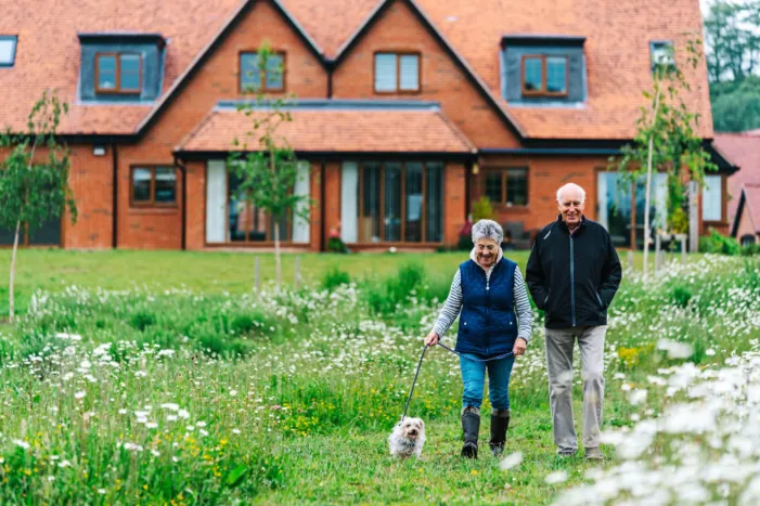A couple walking a dog at Great Alne Park