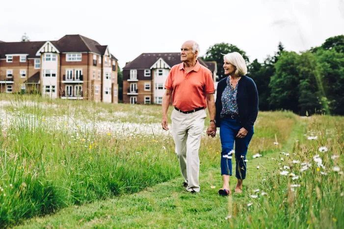 Older couple walking through meadow
