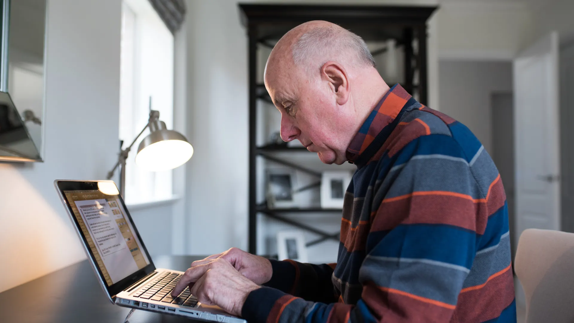 An older man using a laptop