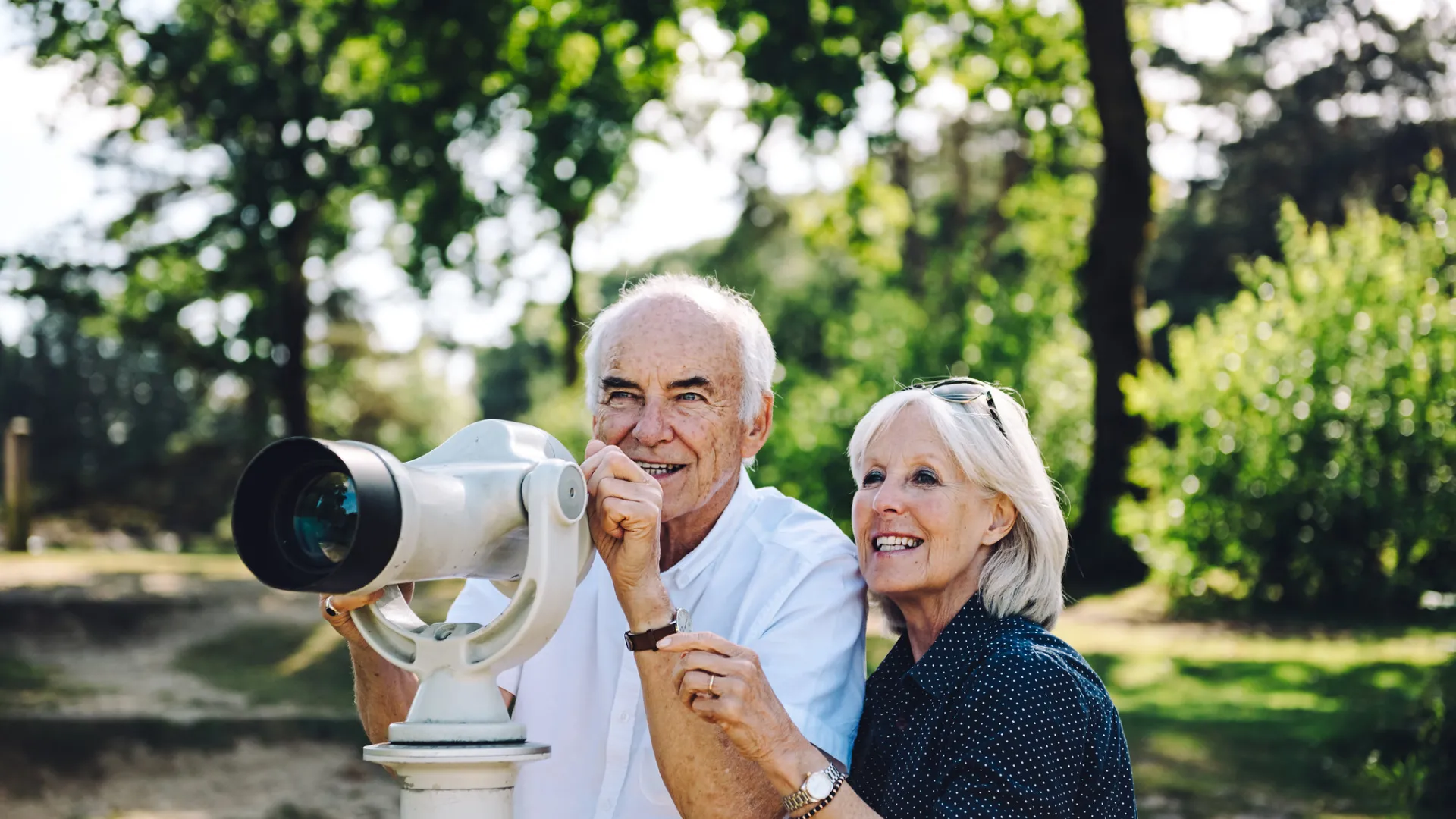A man and a women looking through binoculars 