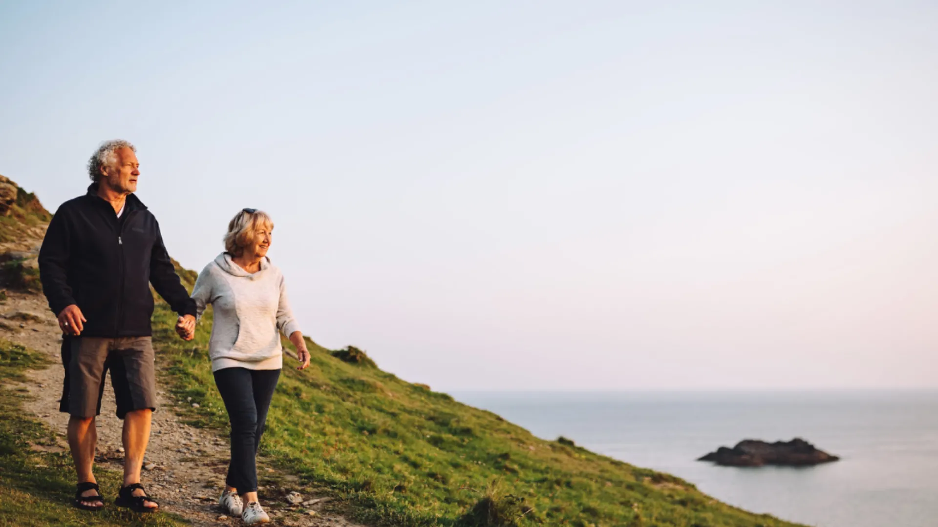 A couple walking on the coast in Devon