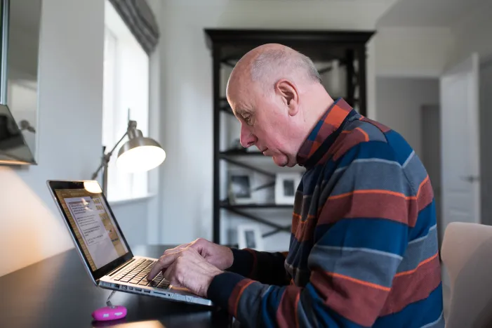An older man using a laptop