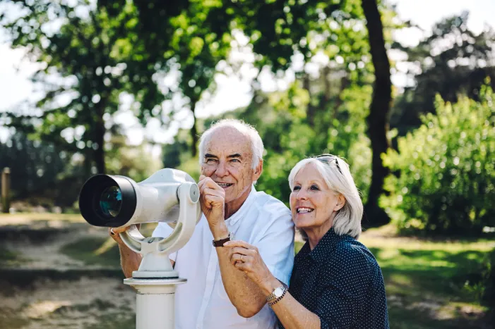 A man and a women looking through binoculars 